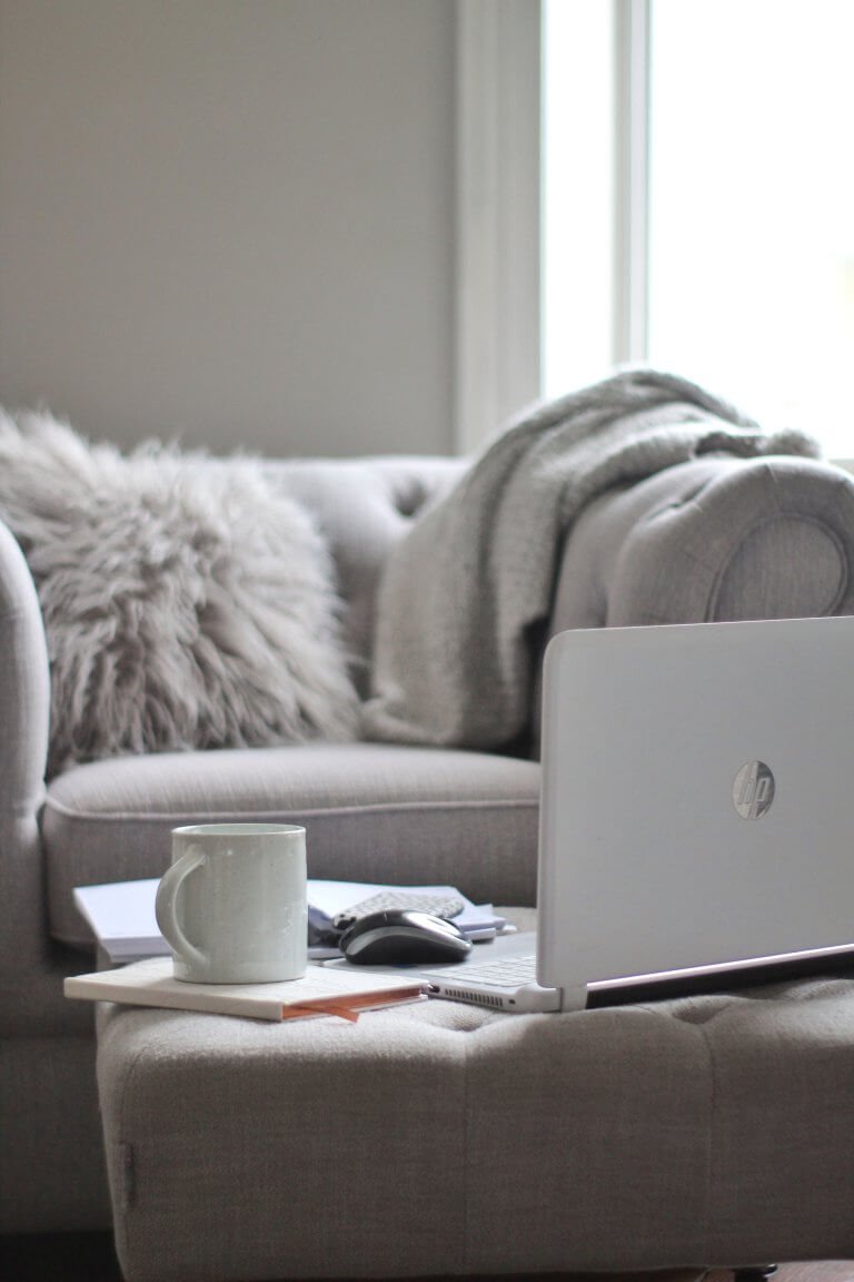 Grey sofa with laptop and cup by Wildflower Pinterest Management in the UK
