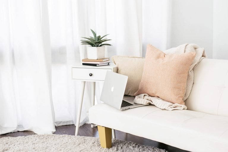 Stock photograph of a laptop on a white sofa